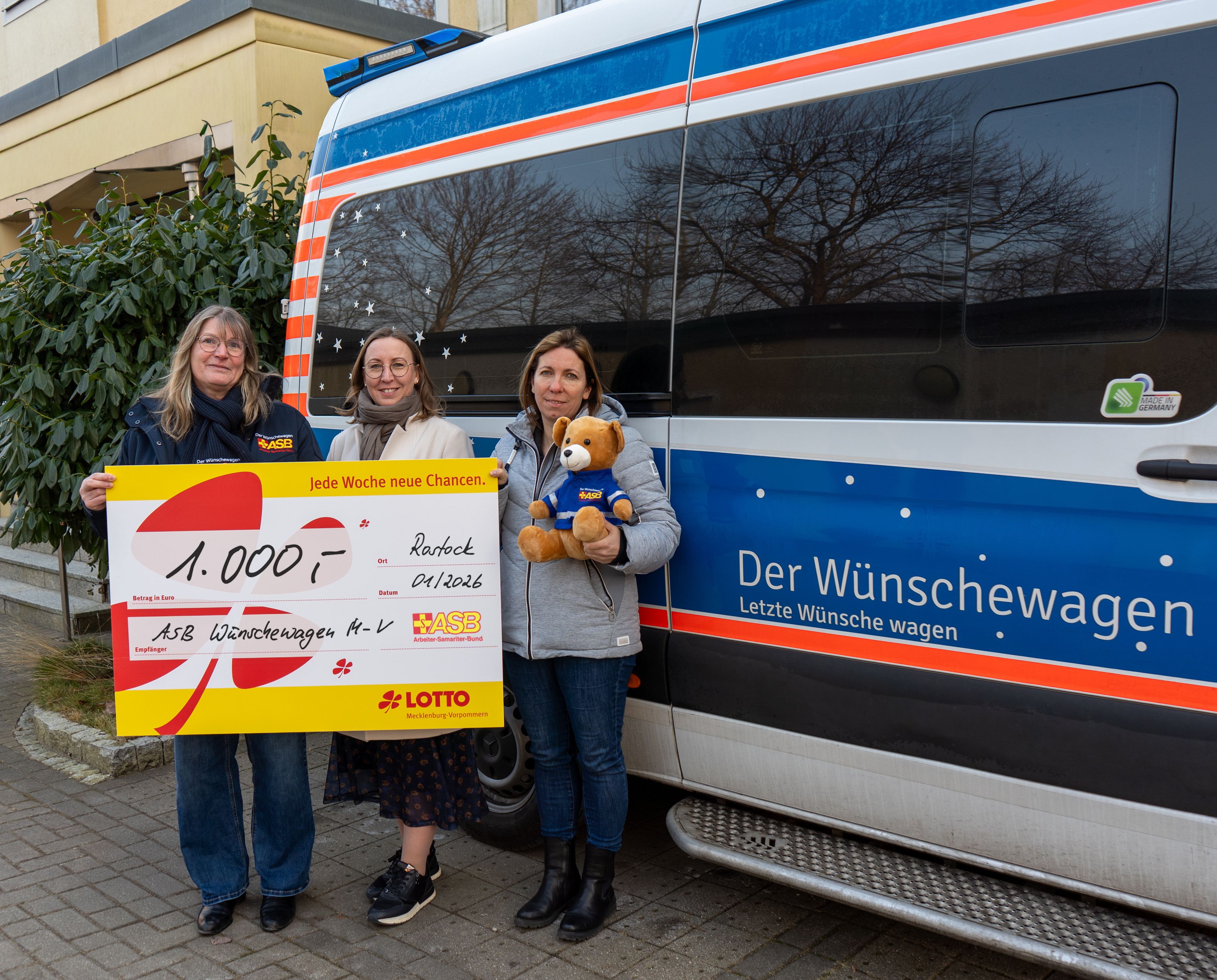 Karen Herborn bekommt stellvertretend für alle  ehrenamtlichen Helfenden des ASB Wünschewagen M-V den  Spendenschenk in Höhe von 1.000 Euro von Elisabeth Aßmann und  Fanny Scharein überreicht